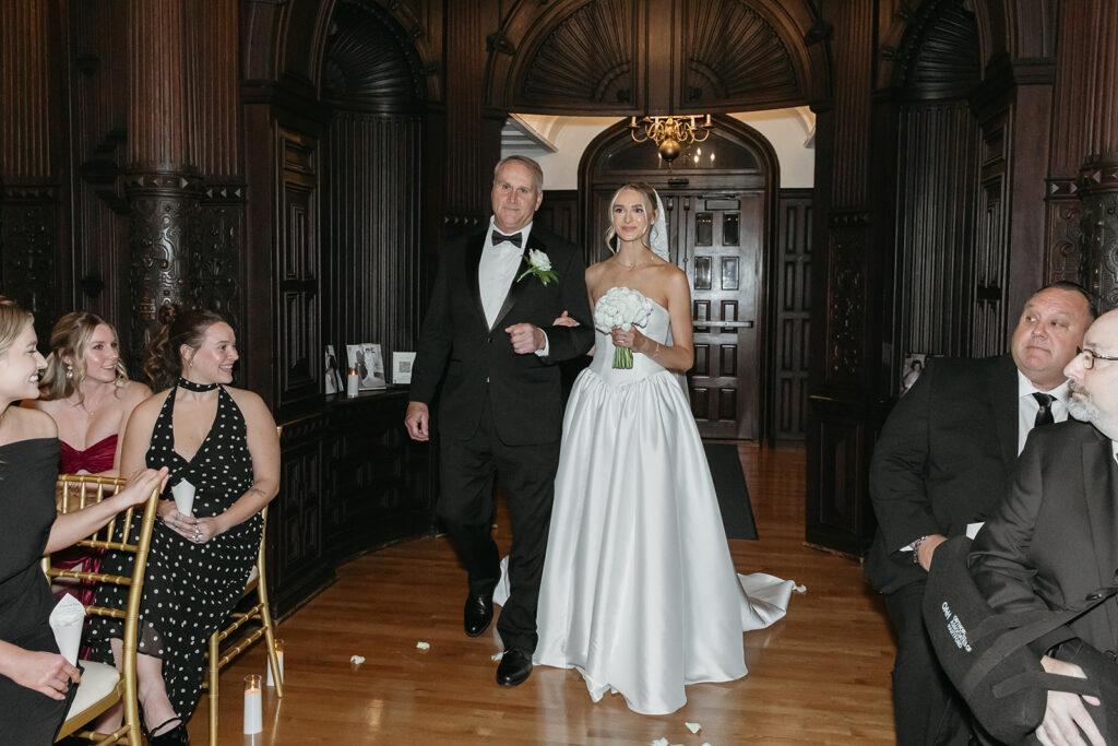 bride walking down the aisle with dad full of candles