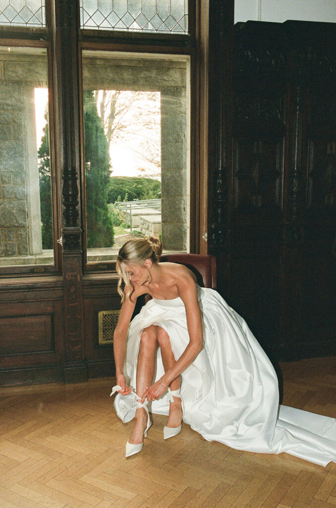 35mm film photo of the bride putting on her shoes