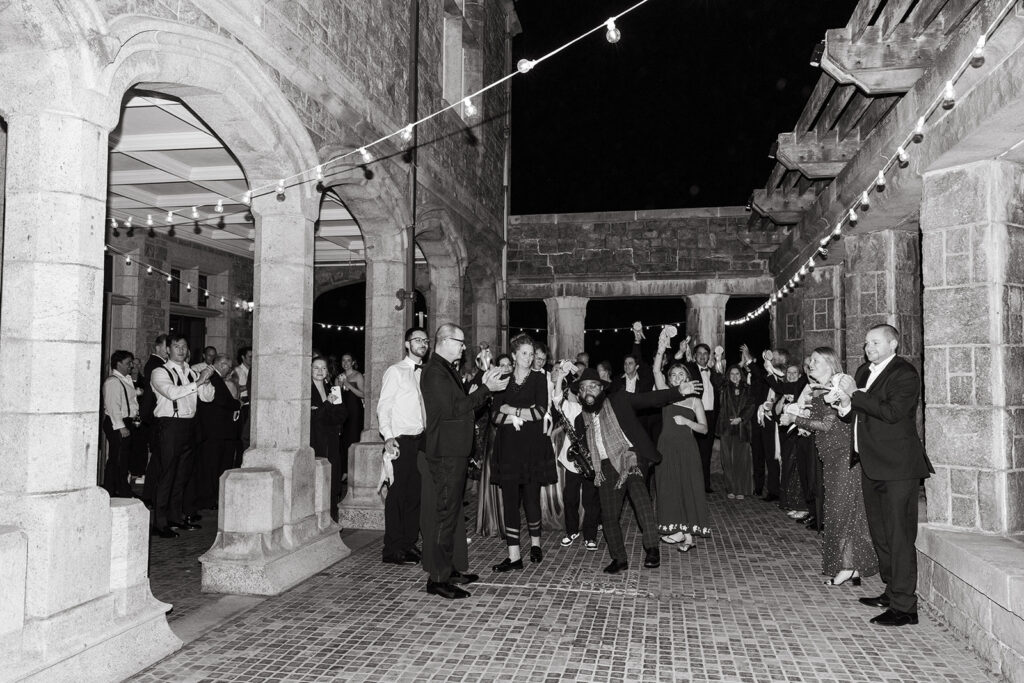 Guests celebrating outside on the patio after the couple drove off